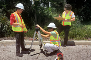 Bowman summer interns in safety vests inspecting equipment.