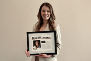 Mandy Leesch holding Northwest Arkansas Business Journal Forty Under 40 award article.