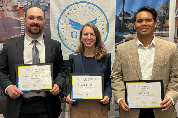 Image of three Bowman team members holding TDM Professionals Under 40 award certificates.